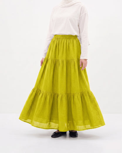 Girle wearing a long Yellow Layered Double Closhe Skirt and white top on a white background